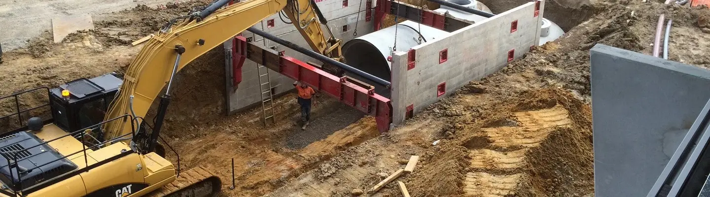 Multiple machines and equipment excavating soil at a construction site, preparing the ground for building foundations or infrastructure.