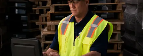 man in hardhat on computer