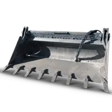 A loader bucket attached to heavy machinery, positioned to scoop or carry construction materials on a worksite.