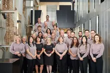 Employees gathered at a workplace event, smiling and celebrating 16 years of company success and teamwork.