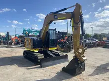 Parked excavator, positioned near safety barriers used for site control and hazard prevention.